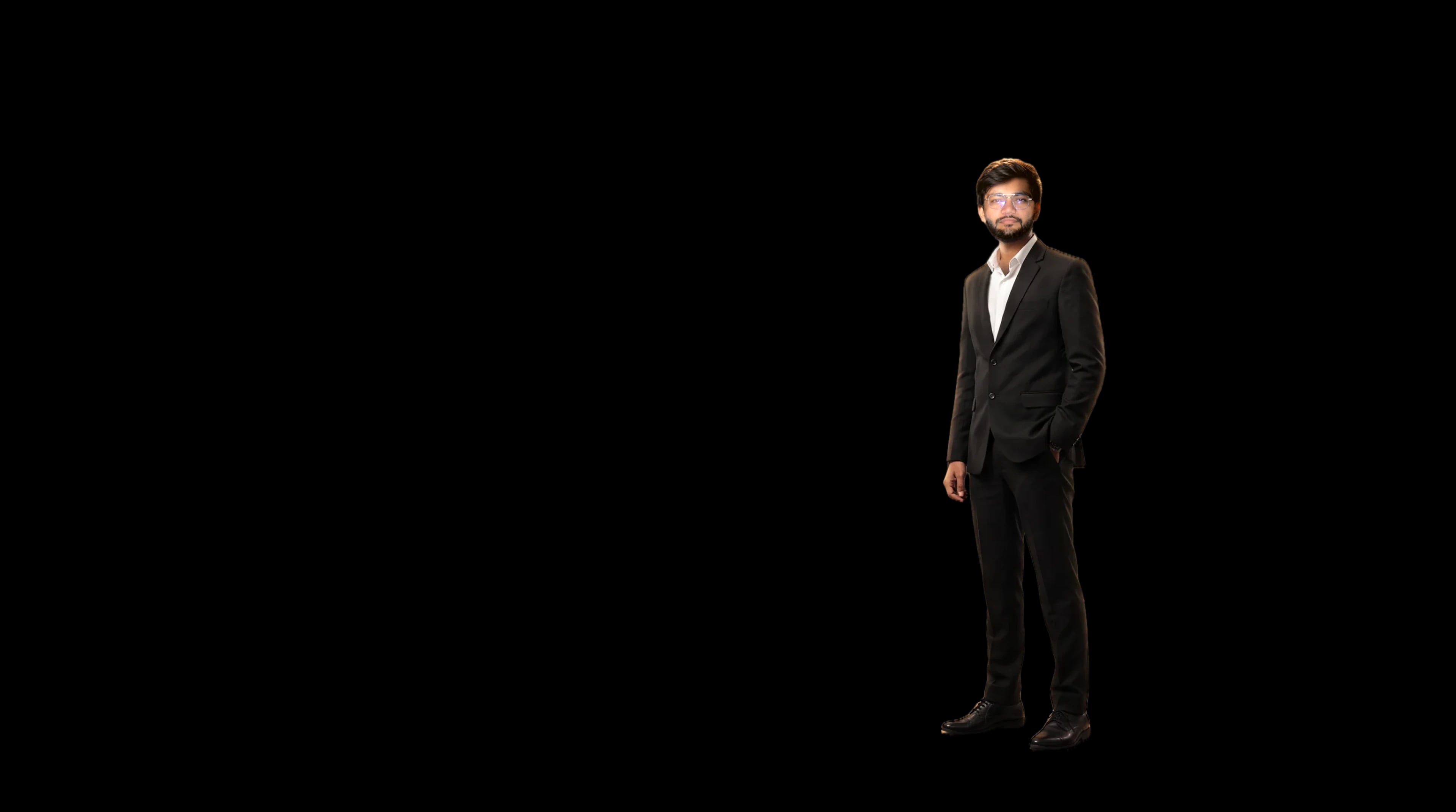 Nil Sakariya in a black suit under a spotlight on a dark stage
